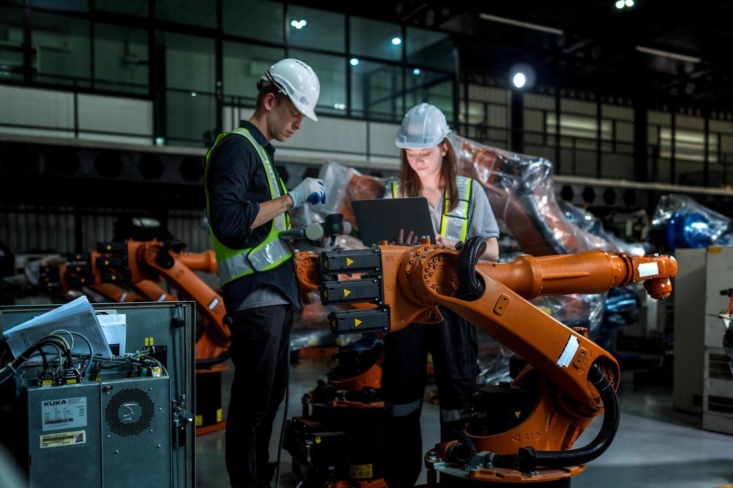 team engineers inspecting on machine with smart tablet. Worker works at heavy machine robot arm. The welding machine with a remote system in an industrial factory. Artificial intelligence concept. photo