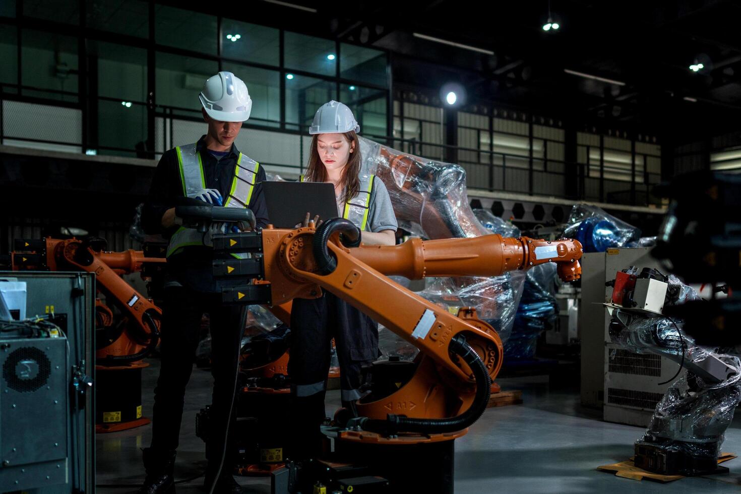 team engineers inspecting on machine with smart tablet. Worker works at heavy machine robot arm. The welding machine with a remote system in an industrial factory. Artificial intelligence concept. photo