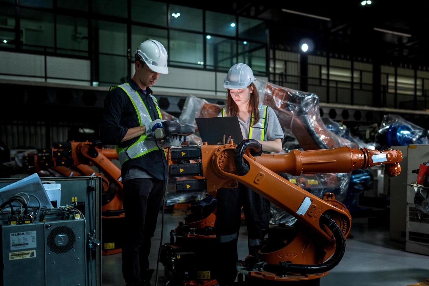 team engineers inspecting on machine with smart tablet. Worker works at heavy machine robot arm. The welding machine with a remote system in an industrial factory. Artificial intelligence concept. photo