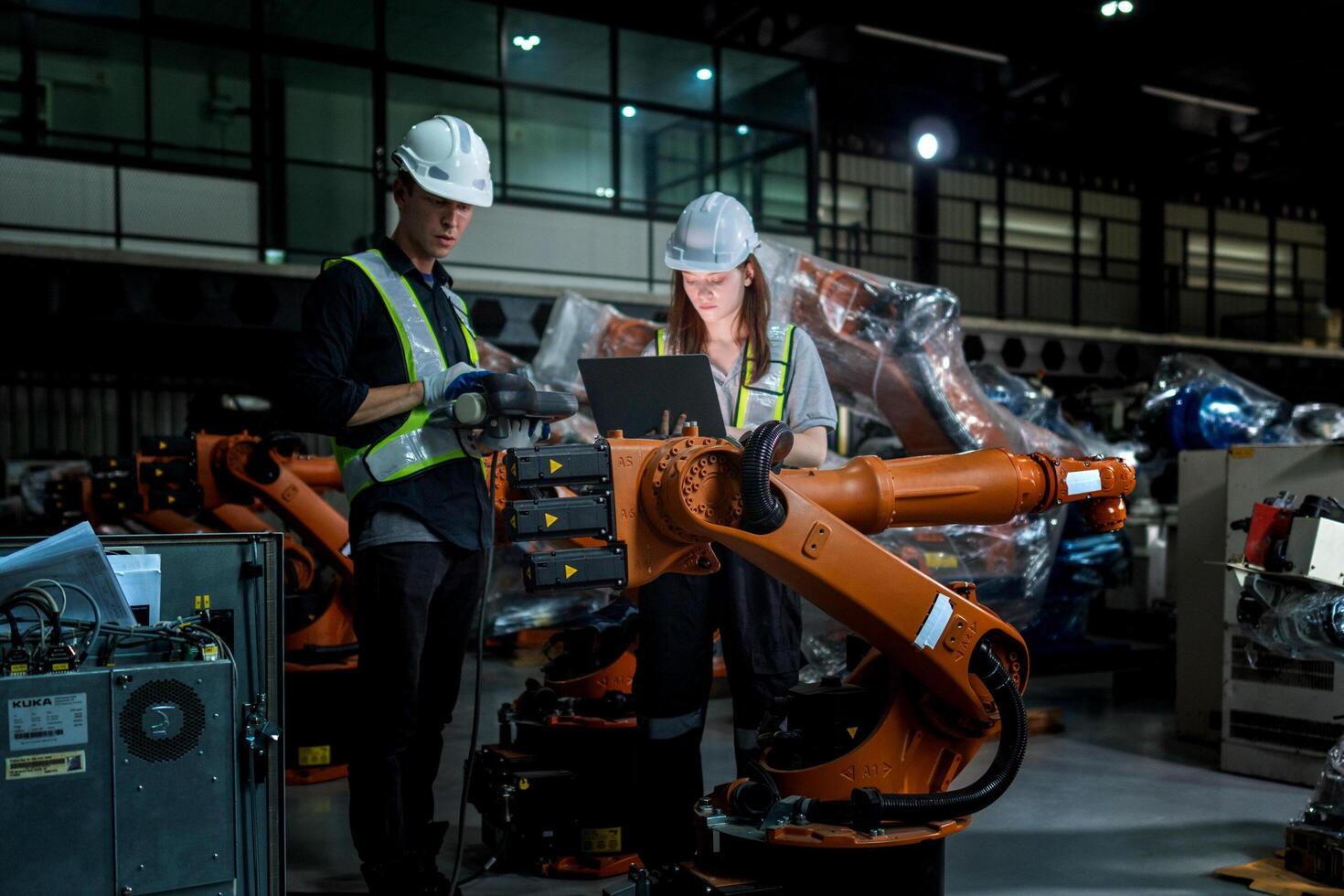 team engineers inspecting on machine with smart tablet. Worker works at heavy machine robot arm. The welding machine with a remote system in an industrial factory. Artificial intelligence concept. photo