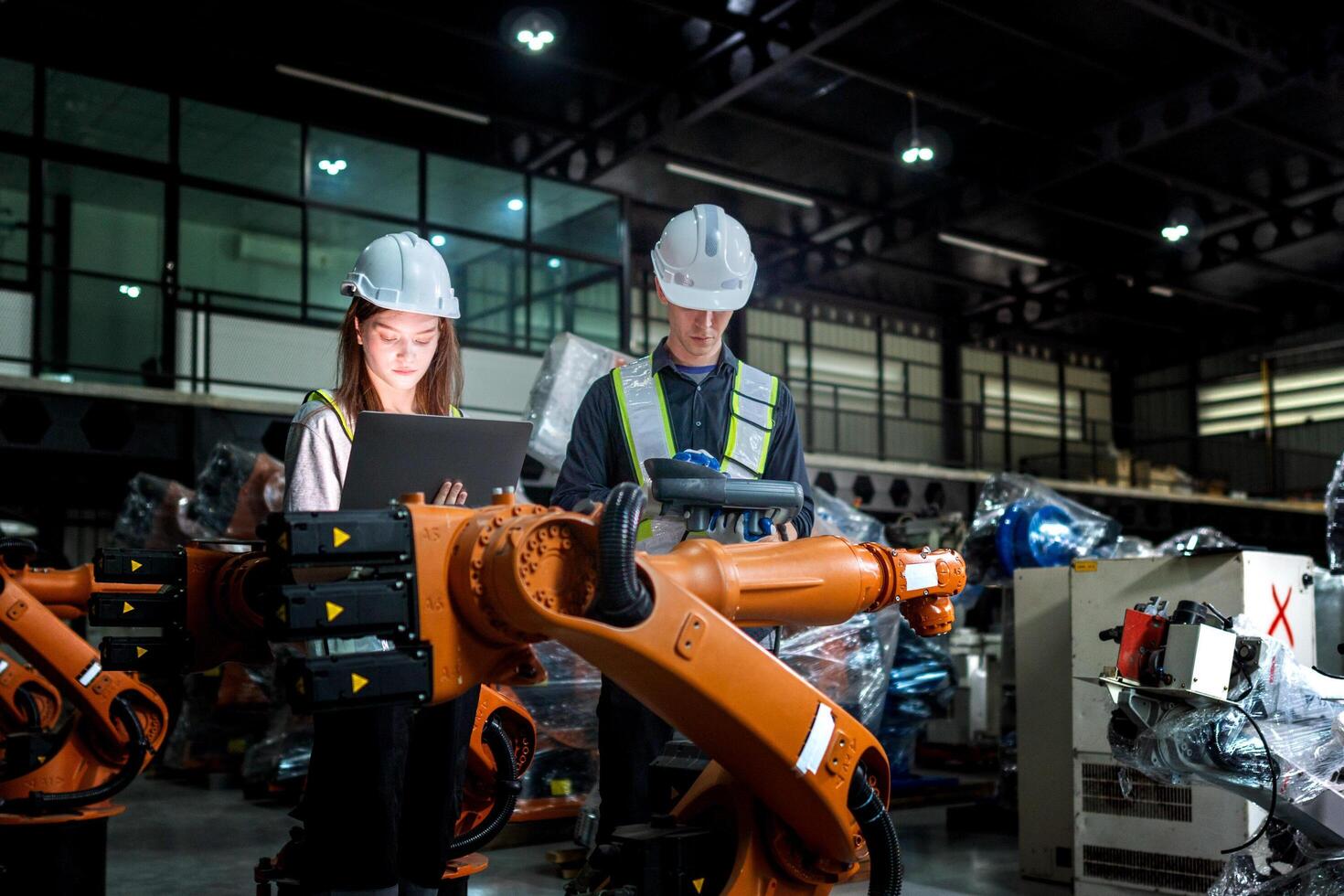 team engineers inspecting on machine with smart tablet. Worker works at heavy machine robot arm. The welding machine with a remote system in an industrial factory. Artificial intelligence concept. photo