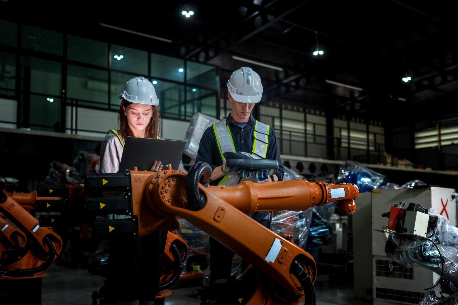 team engineers inspecting on machine with smart tablet. Worker works at heavy machine robot arm. The welding machine with a remote system in an industrial factory. Artificial intelligence concept. photo