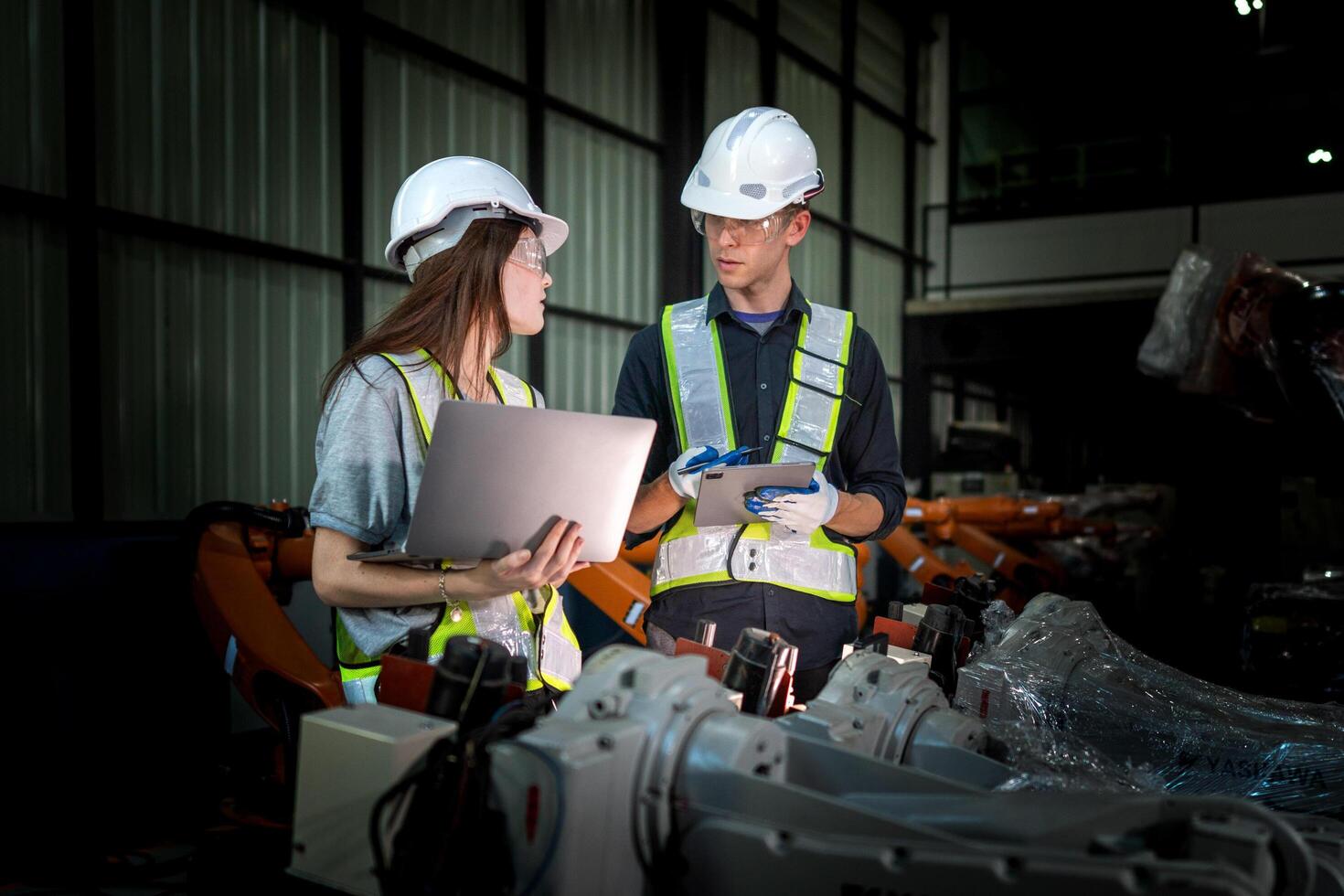 Sales manager and factory owner in suits negotiating selling robots used in the factory. Business engineers meeting and checking new machine robot. Workers walking at warehouse welding machine. photo