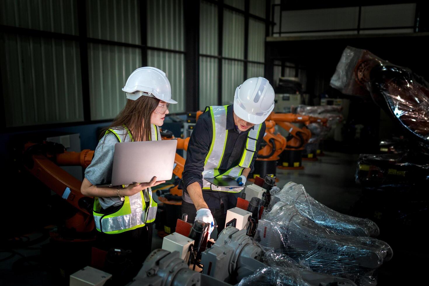 Sales manager and factory owner in suits negotiating selling robots used in the factory. Business engineers meeting and checking new machine robot. Workers walking at warehouse welding machine. photo