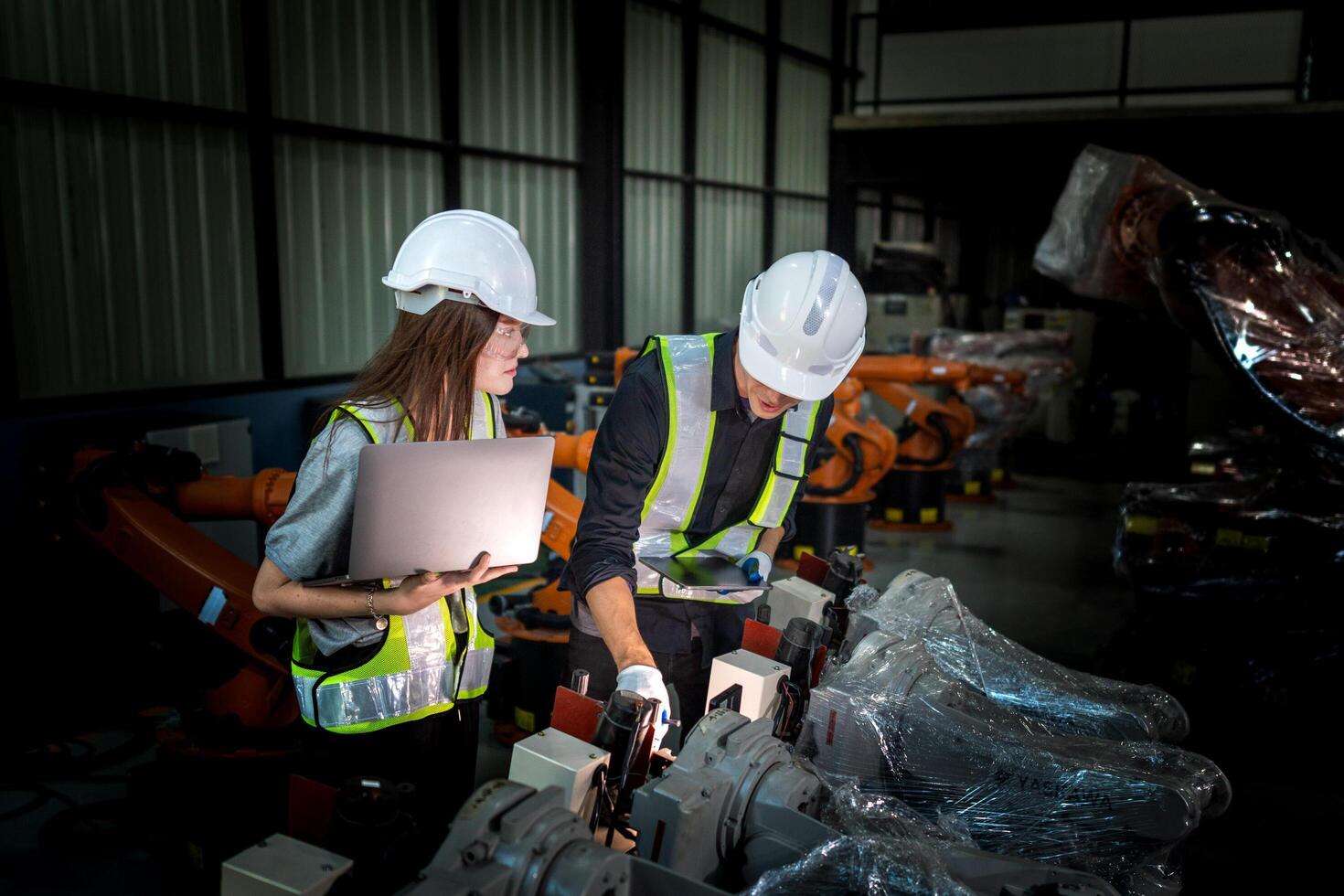Sales manager and factory owner in suits negotiating selling robots used in the factory. Business engineers meeting and checking new machine robot. Workers walking at warehouse welding machine. photo