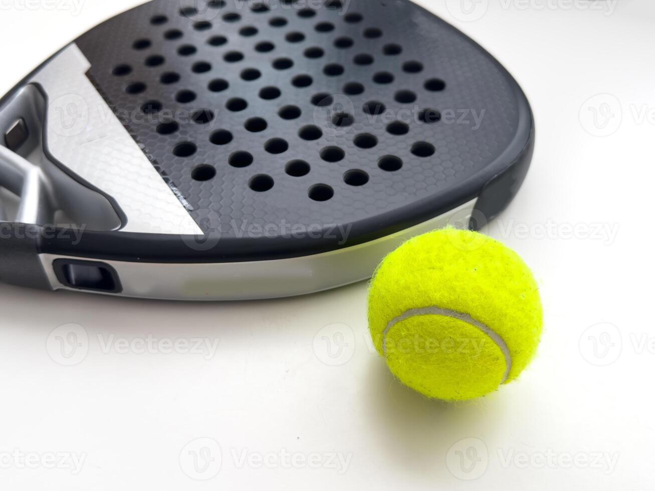 blue professional paddle tennis racket with yellow ball on white background. copy space for text photo