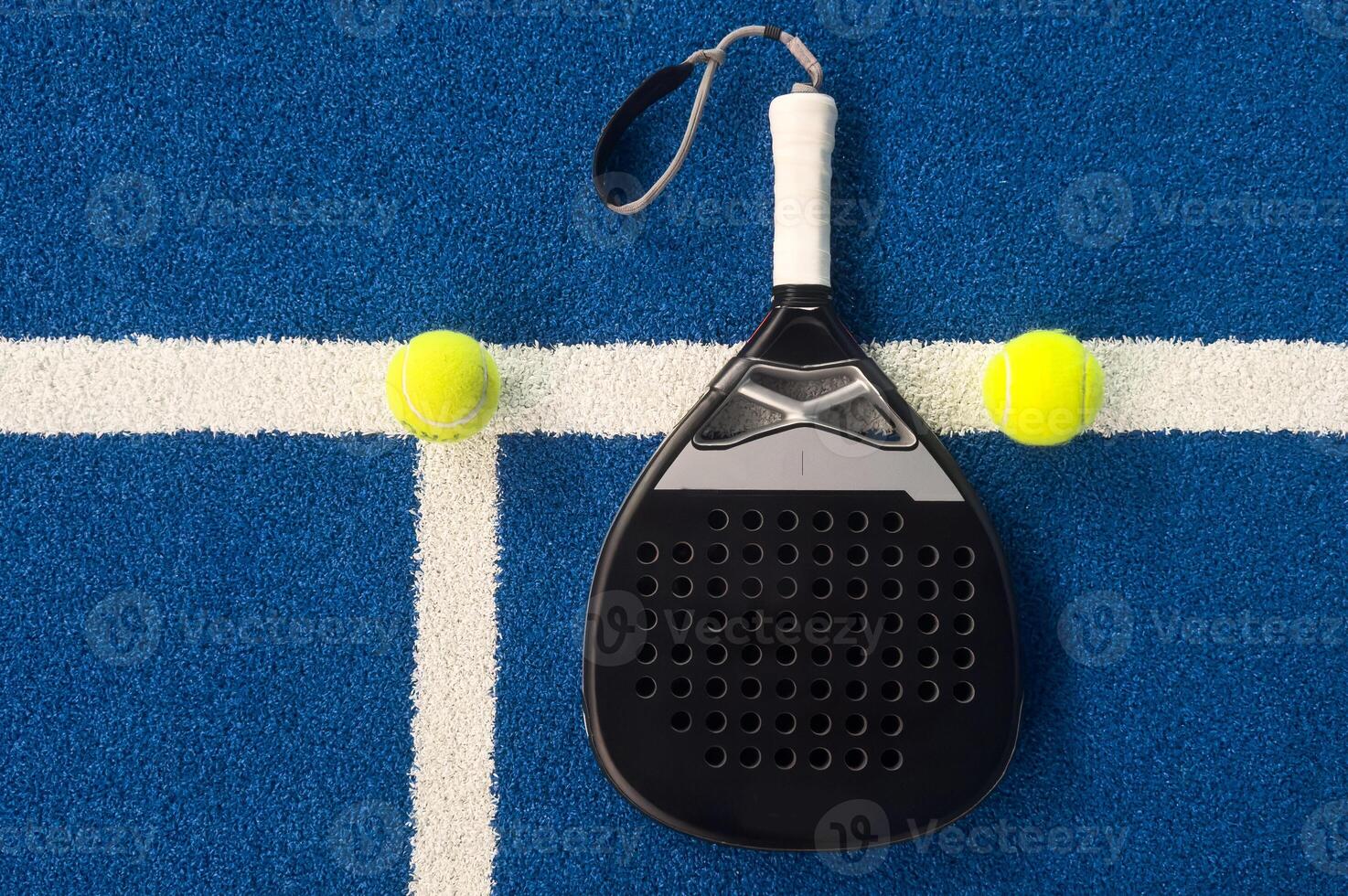 padel racket on a padel blue court with a ball photo