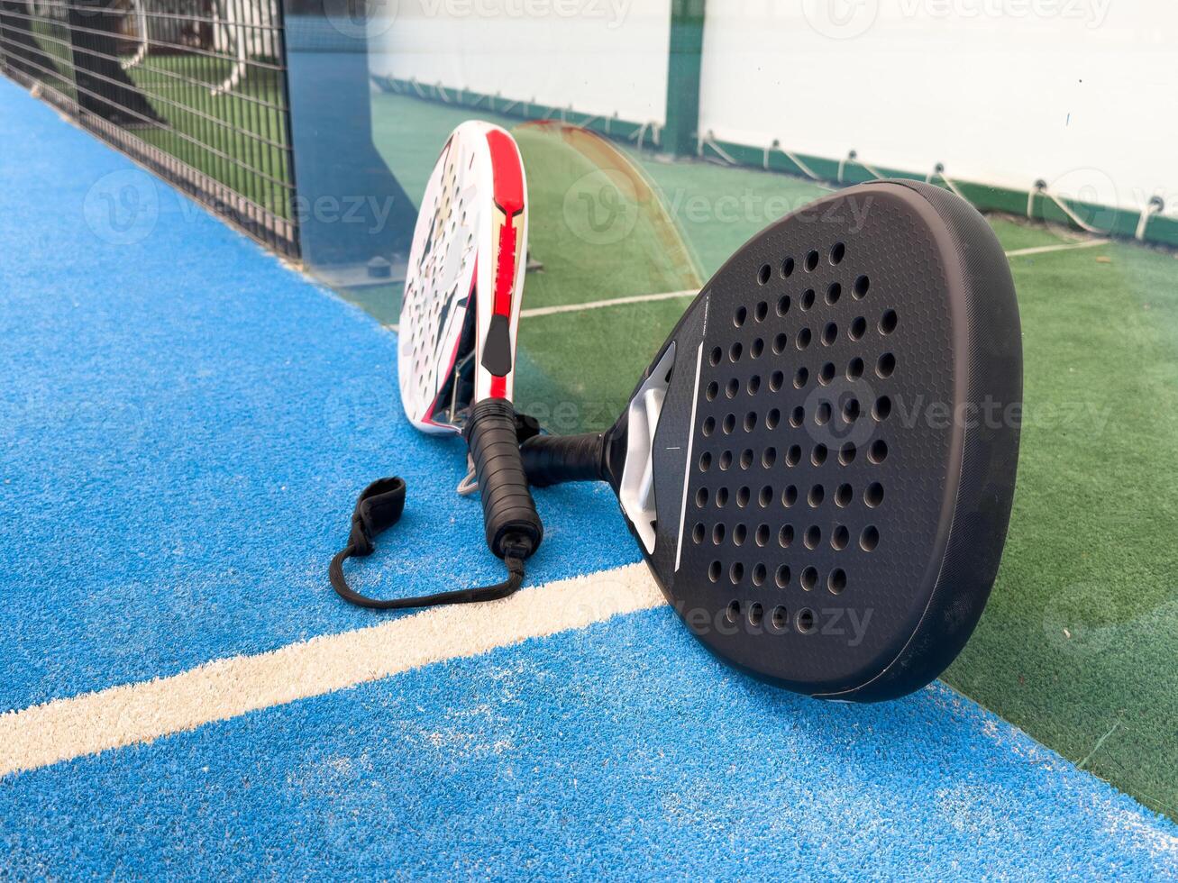 Paddle tennis. Paddel racket and ball in front of an outdoor court photo