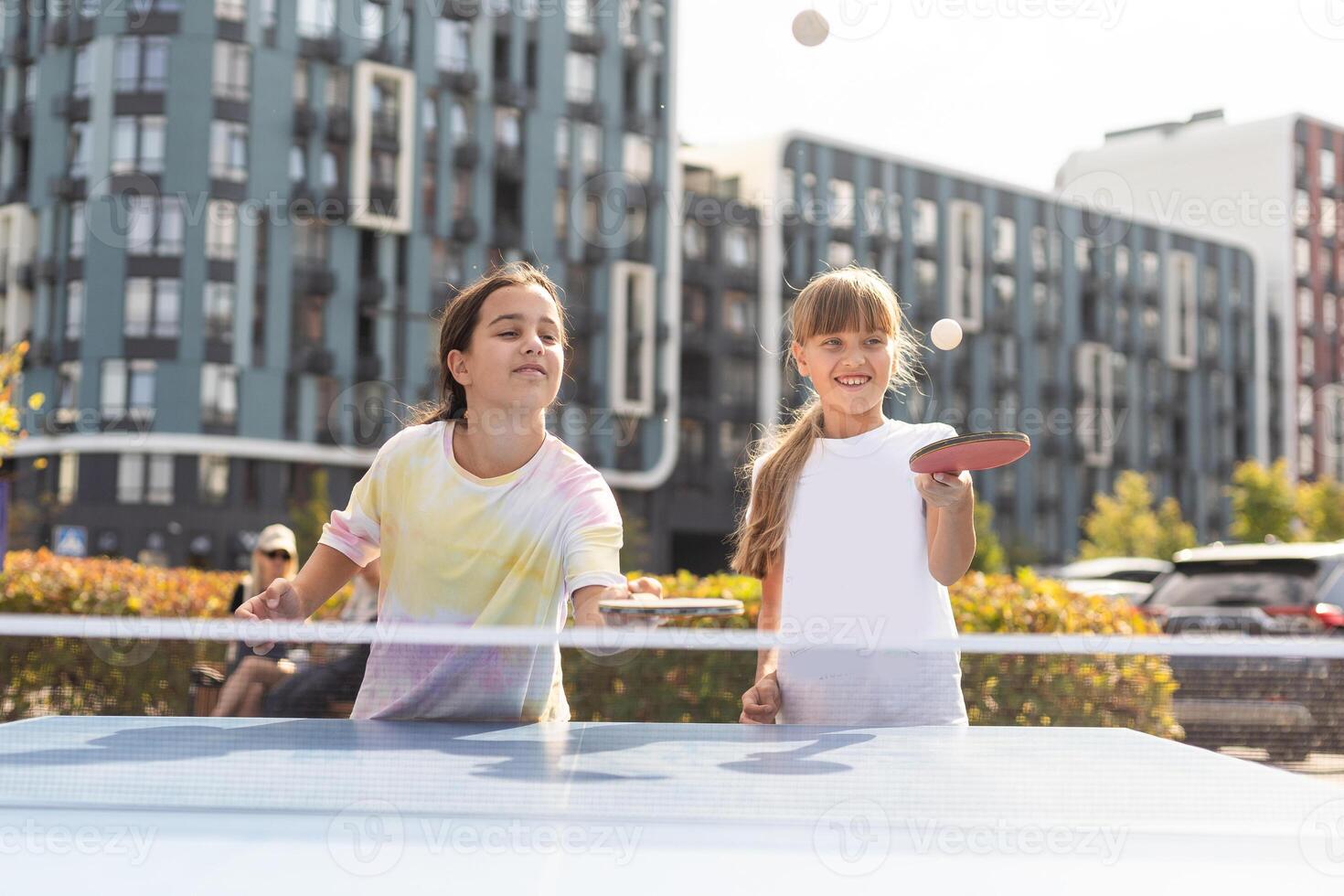 Little children playing ping pong in park photo