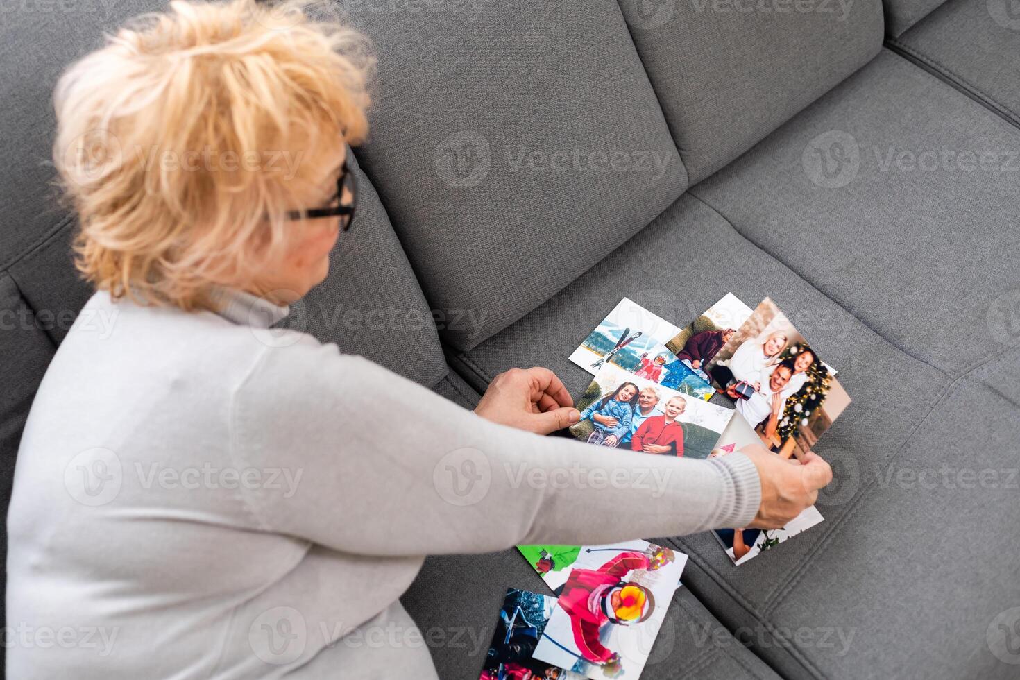 an elderly woman is looking at a photo of her grandchildren