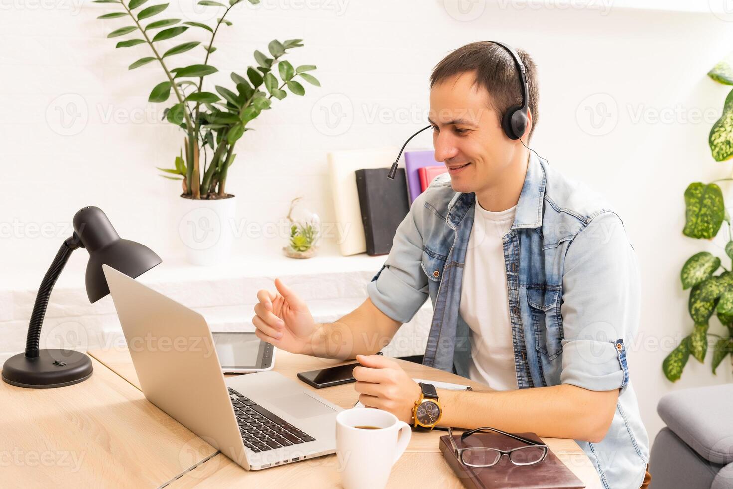 Smiling young man working on laptop, checking email in morning, writing message in social network, happy young male using internet banking service, searching information photo