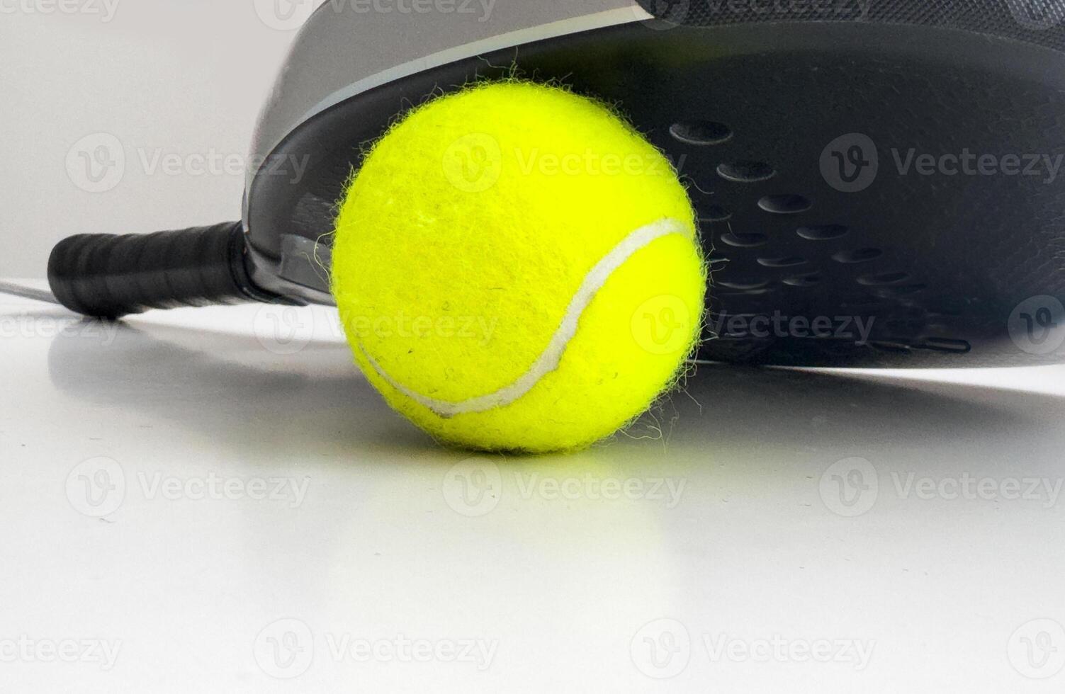 blue professional paddle tennis racket with yellow ball on white background. copy space for text photo