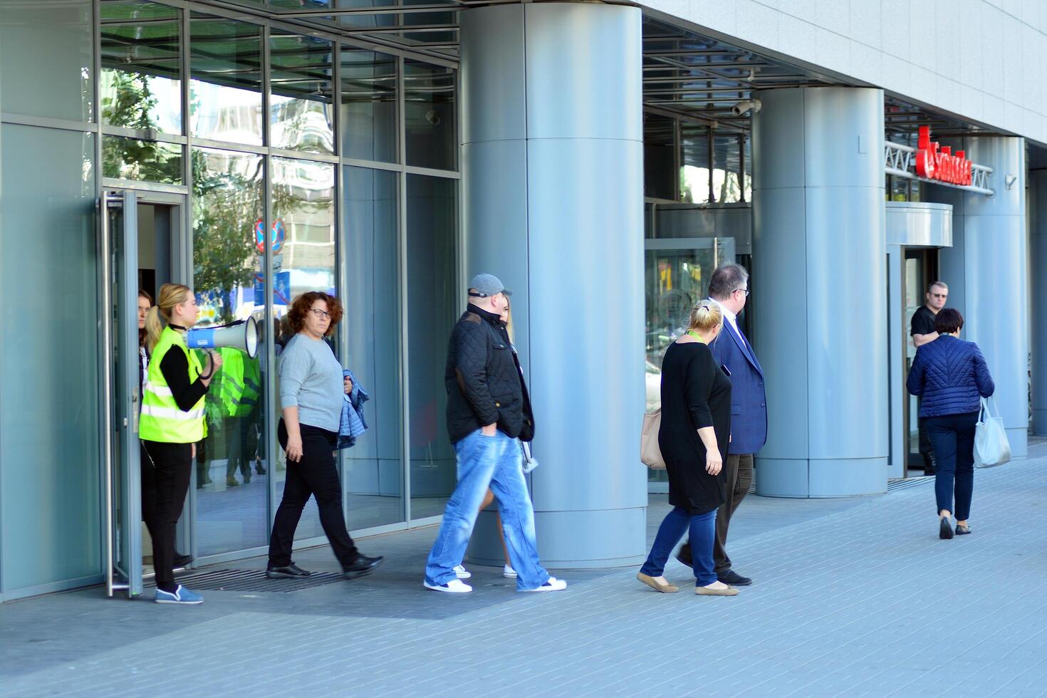 Warsaw, Poland. 15 October 2018. Evacuation of an office building. People exit the building on exit door. photo