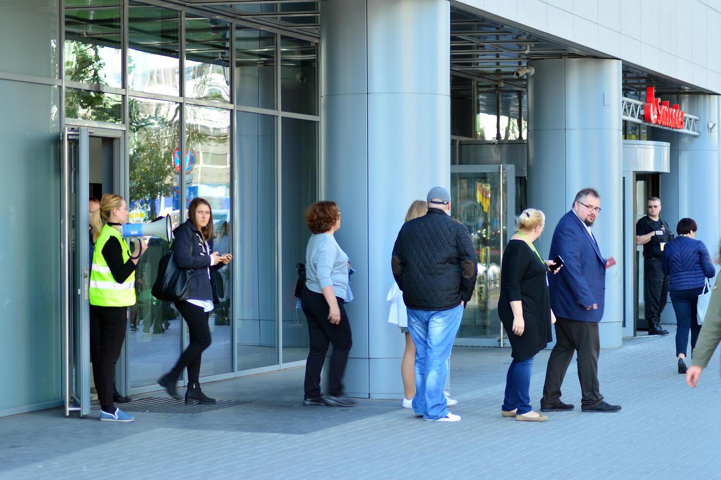Warsaw, Poland. 15 October 2018. Evacuation of an office building. People exit the building on exit door. photo