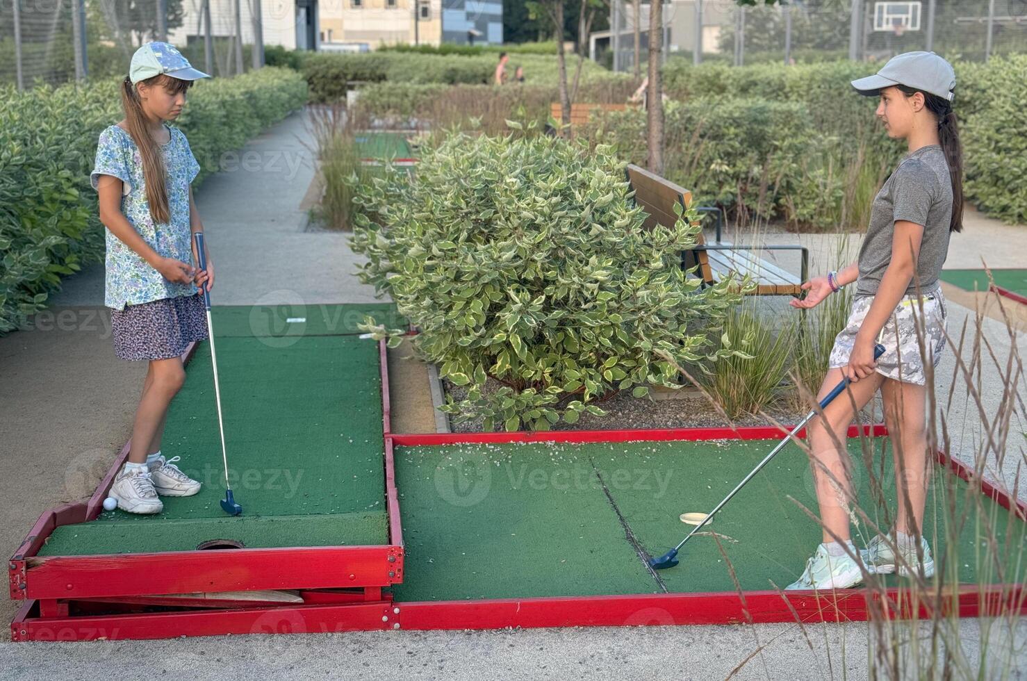 teenage girls play mini golf photo