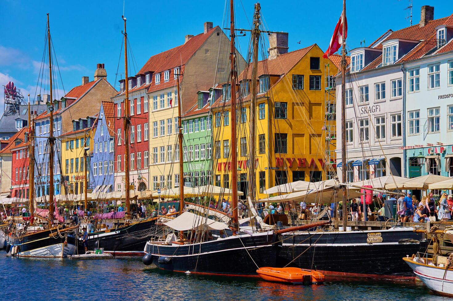 Nyhavn Harbor in Copenhagen. Famous tourist spot in Denmark with colorful historical buildings and boats on Nyhavn waterfront. Traveling in Scandinavian country. Copenhagen, Denmark - June 26, 2024 photo