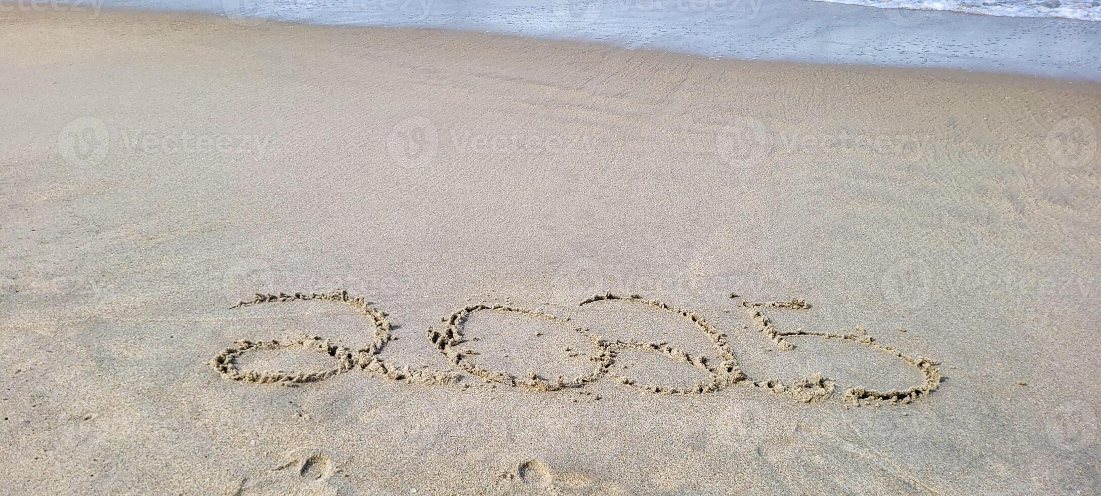 happy 2025 written in the sand of itamambuca ubatuba beach photo