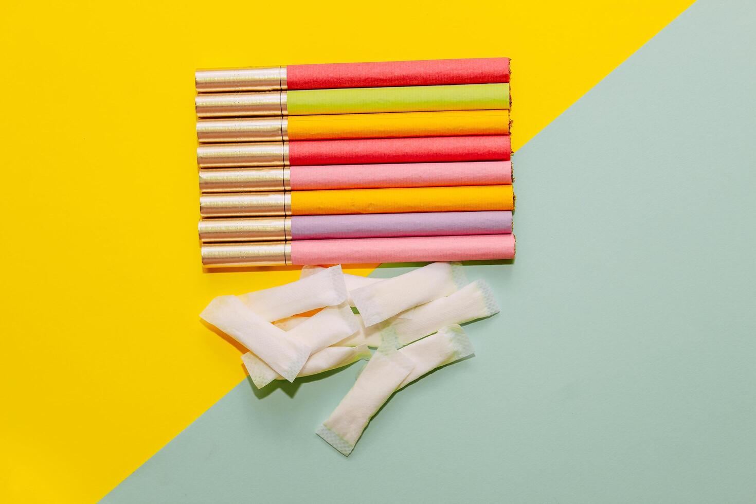 Multicolored cigarettes and snus pads on a paper background, the concept of a bad habit. photo