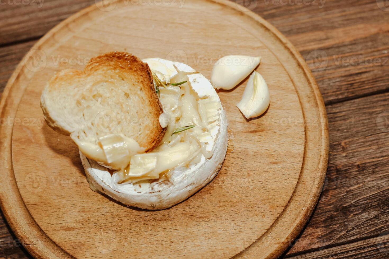 White baguette with olive oil and baked Camembert cheese on the table photo