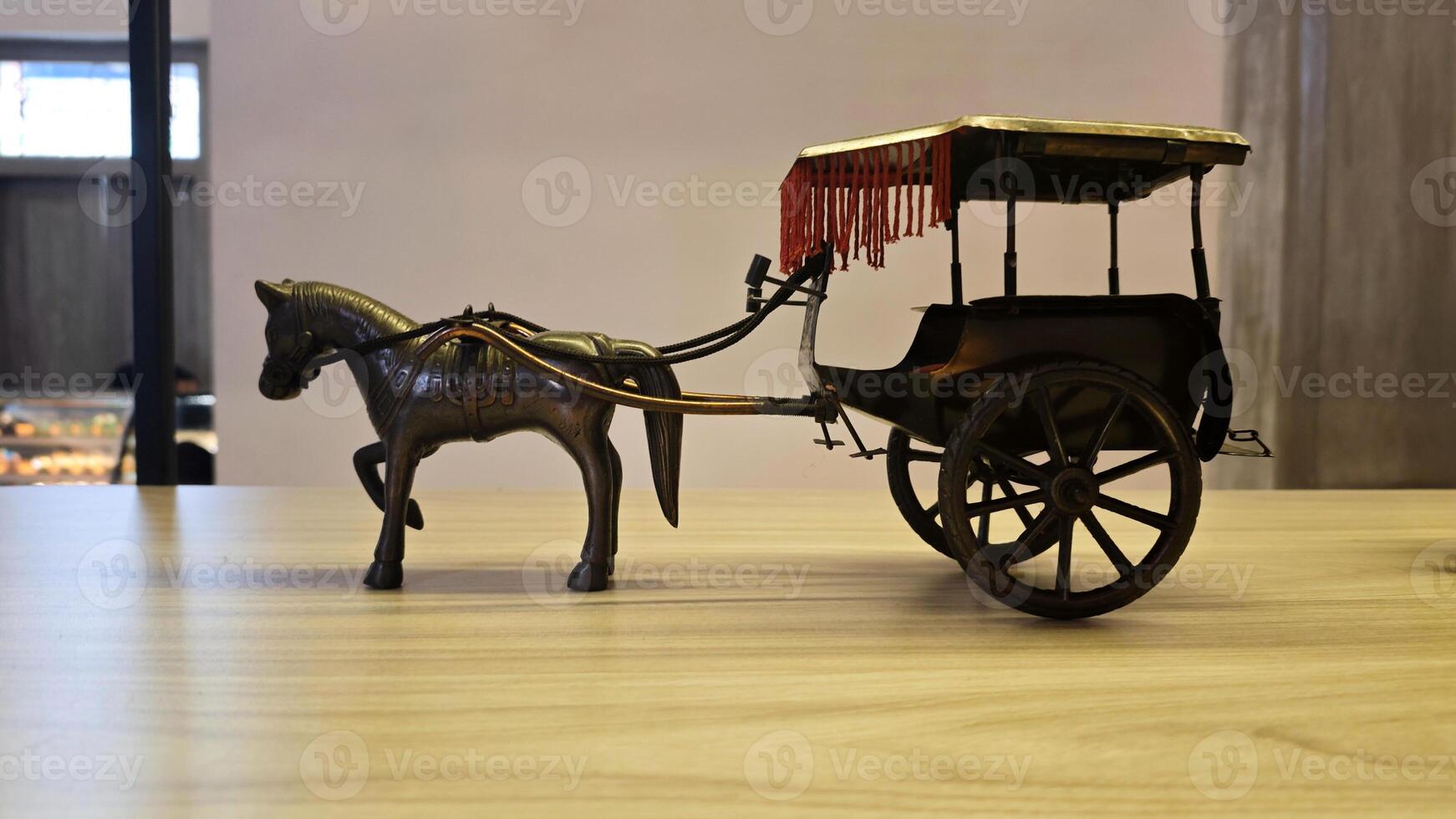 Detailed Miniature Vintage Horse Carriage on Wooden Table in Indoor Setting with Subtle Background Lighting photo