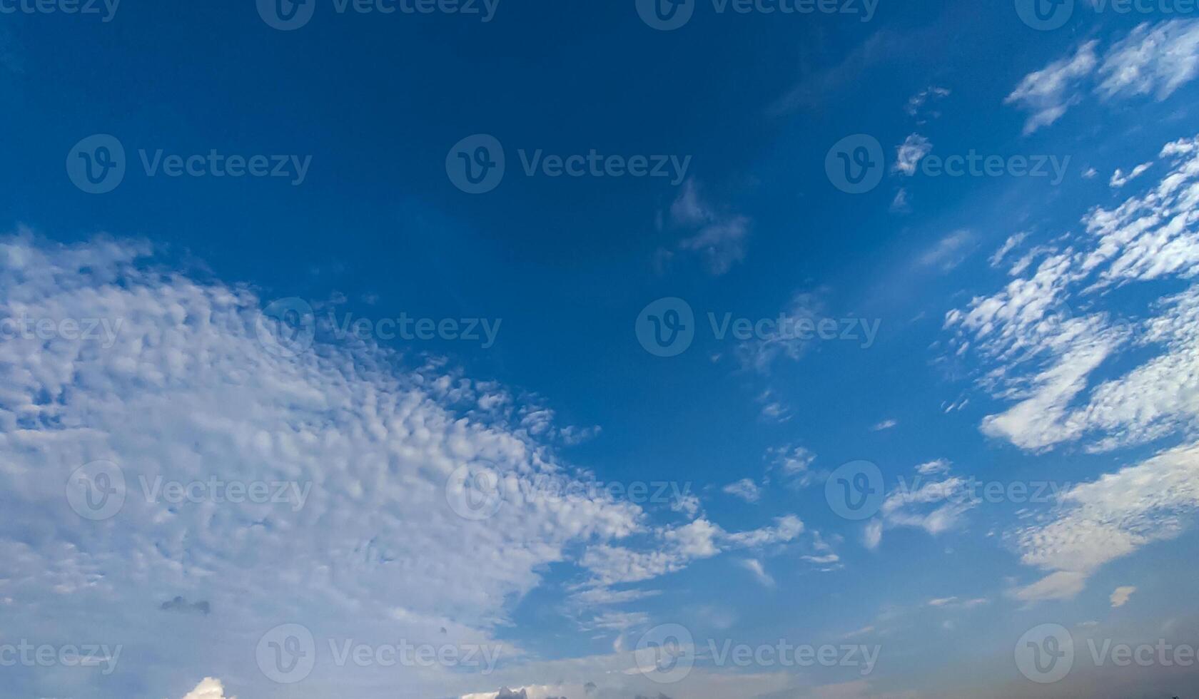 a view of the sky from a boat on a lake, a blue sky that has white some clouds photo