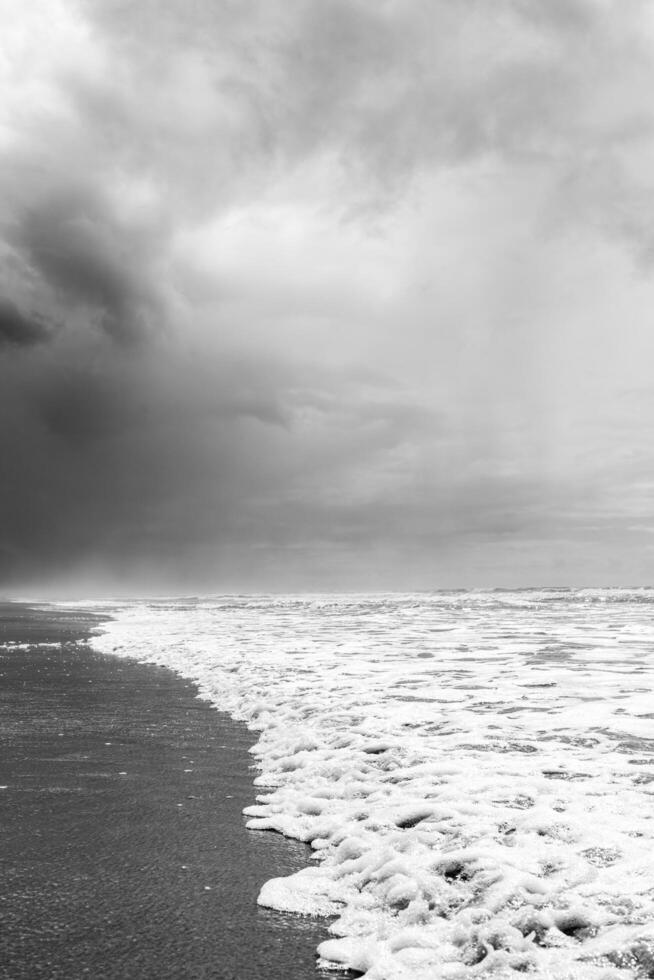 clouds on lonely beach with waves photo