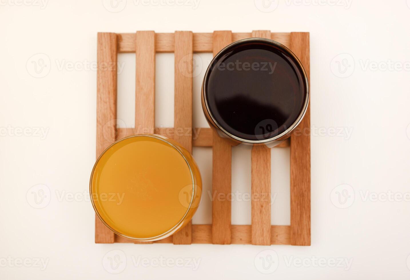 Juice in glass cups on a stand. Cherry and orange juice. photo