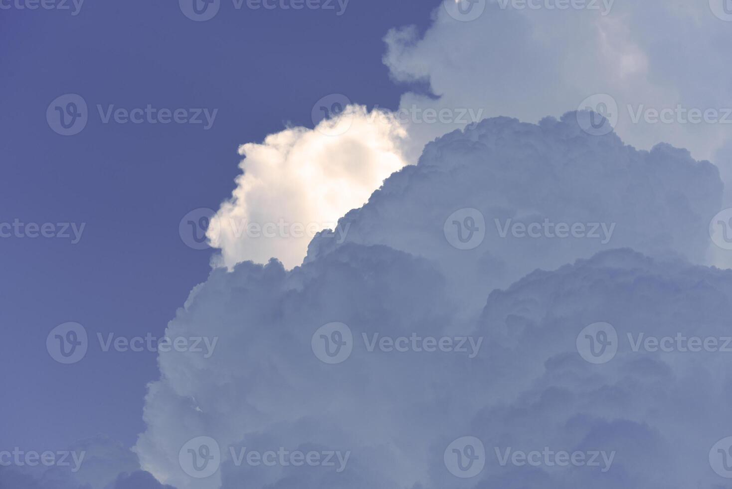 Blue-white cumulus clouds in the rays of the sun. Thunderstorm clouds. photo