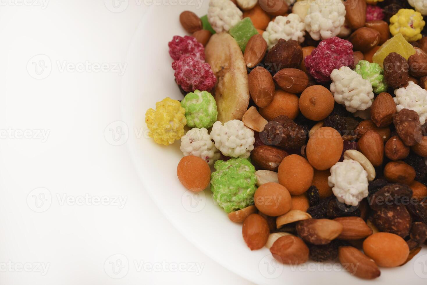 Sweet assorted nuts and dried fruits in a plate on a white background. photo