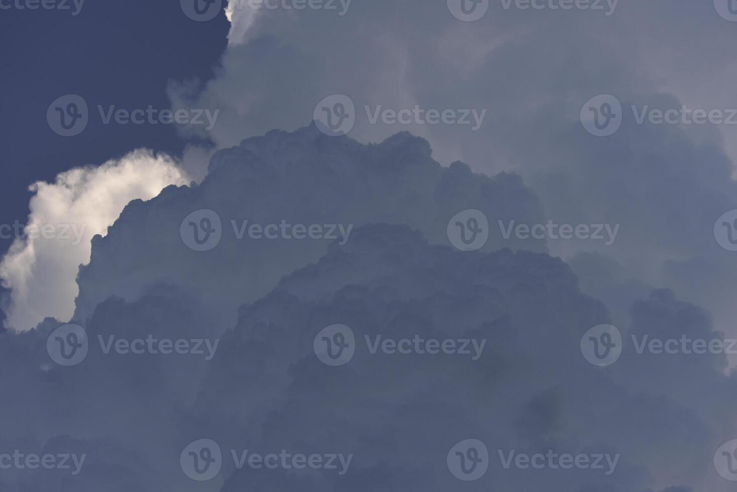 Blue-white cumulus clouds in the rays of the sun. Thunderstorm clouds. photo