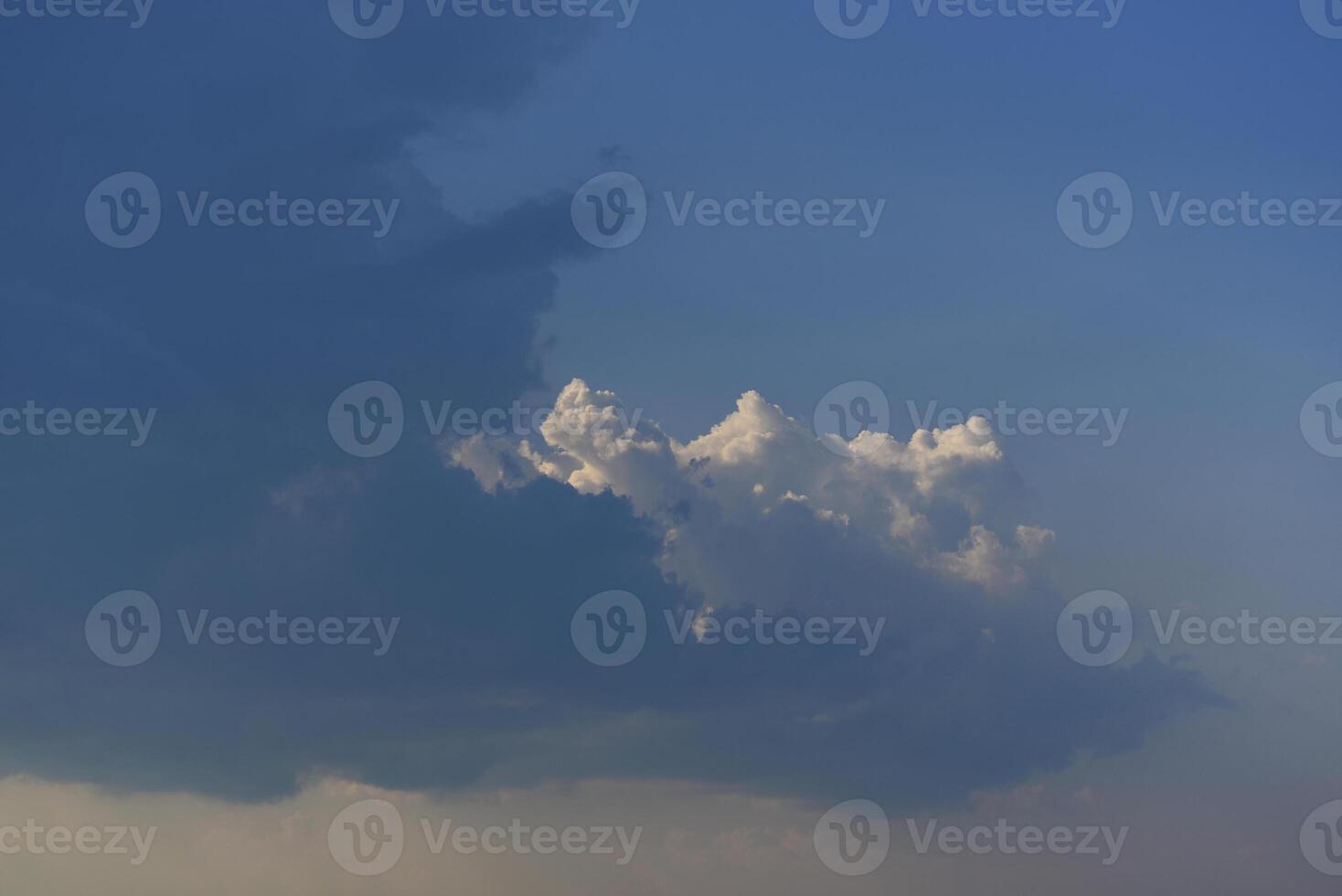 Blue-white cumulus clouds in the rays of the sun. Thunderstorm clouds. photo