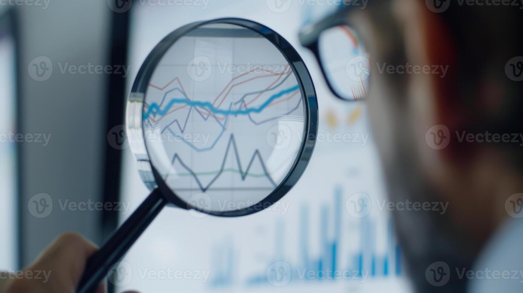 Close-Up of Magnifying Glass Focused on Stock Market Indicators with Blurred Background photo
