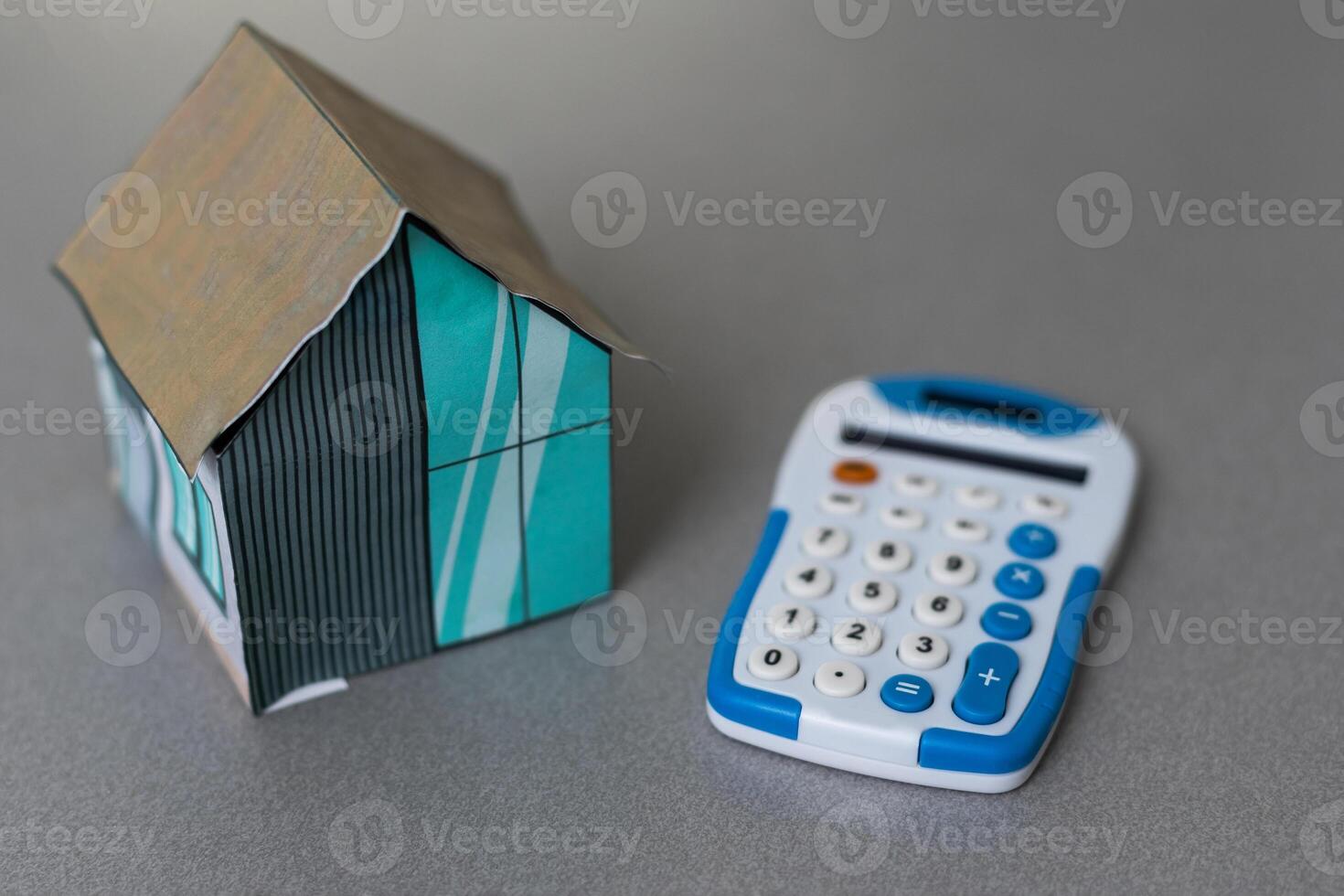 House is placed on the calculator. Imagine calculating to buy a home. planning savings money to buy a home concept for property, mortgage and real estate investment. to buy a house. photo