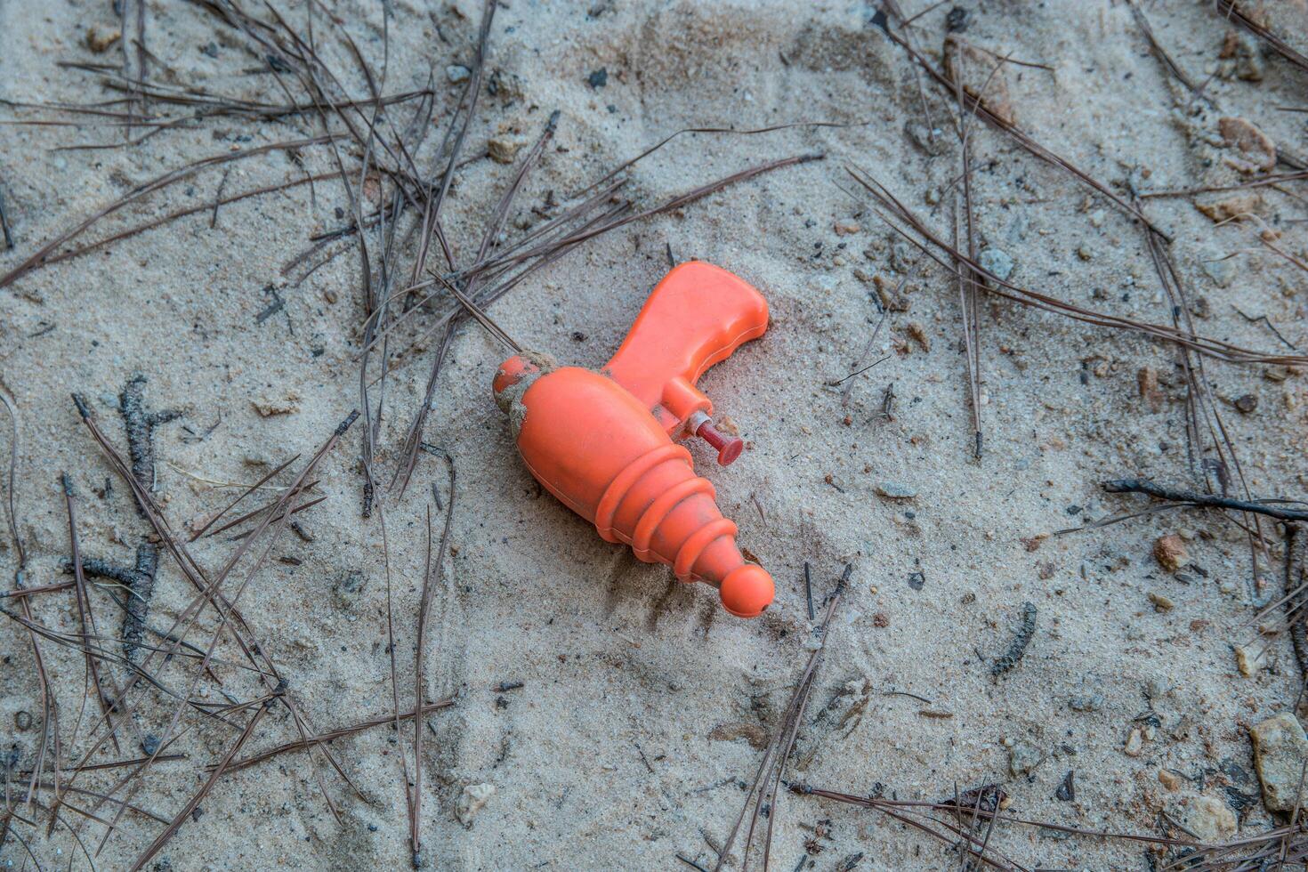 Squirt gun laying on the beach photo