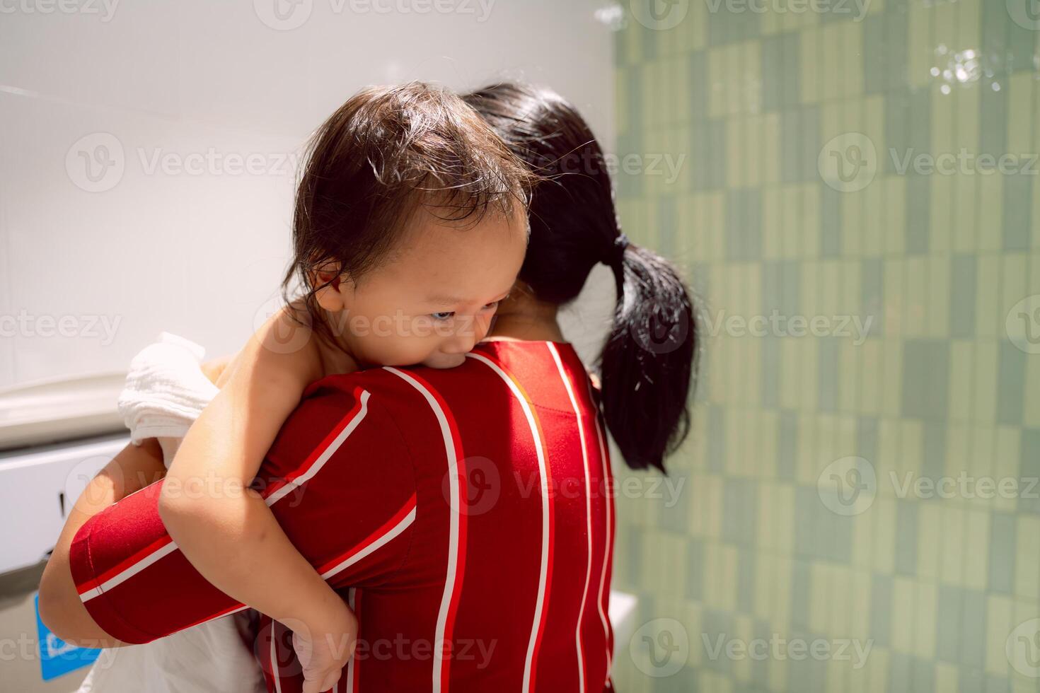 An adorable Asian boy is being dressed or having dressed put on by his mom on the Baby Changing Station, Happy child relaxing time with his mother, Healthcare and Childcare concept. Toddler 1 year old photo