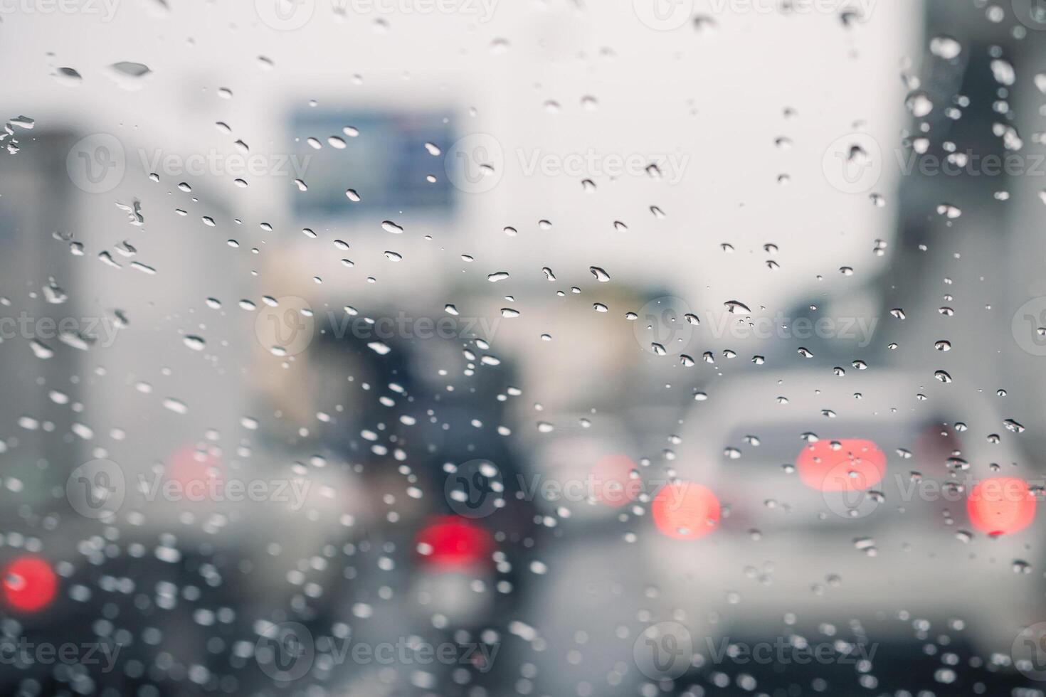 Rain drops on car window and lights. the bokeh image made with traffic and electric lights through the window of car on a rainy day. photo