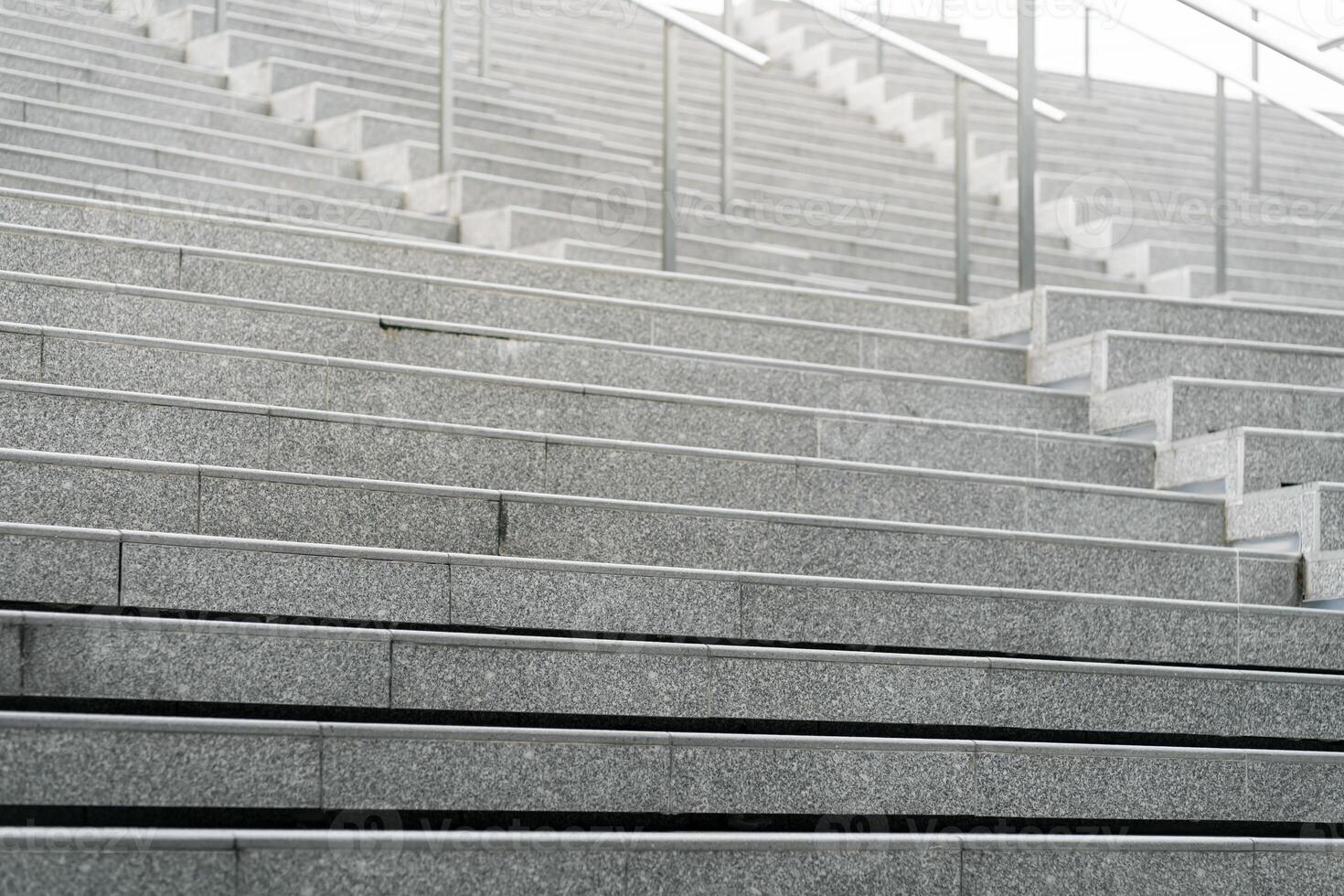 Abstract stairs in black and white, abstract steps, stairs in the city. A modern staircase with wide, smooth concrete steps and sleek stainless steel handrails. photo