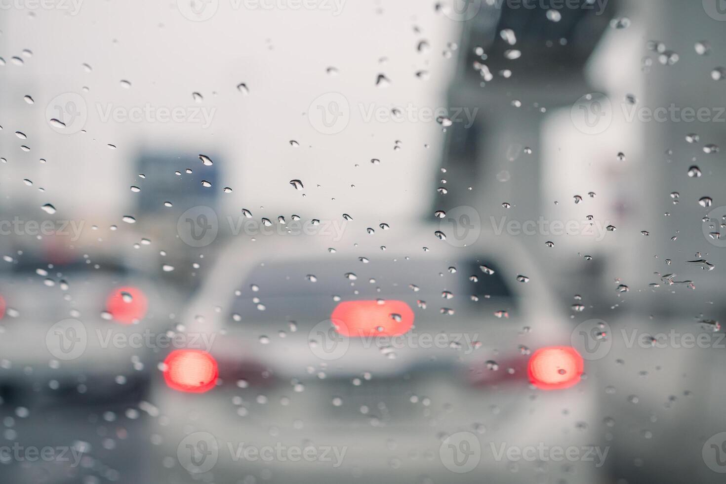 Rain drops on car window and lights. the bokeh image made with traffic and electric lights through the window of car on a rainy day. photo