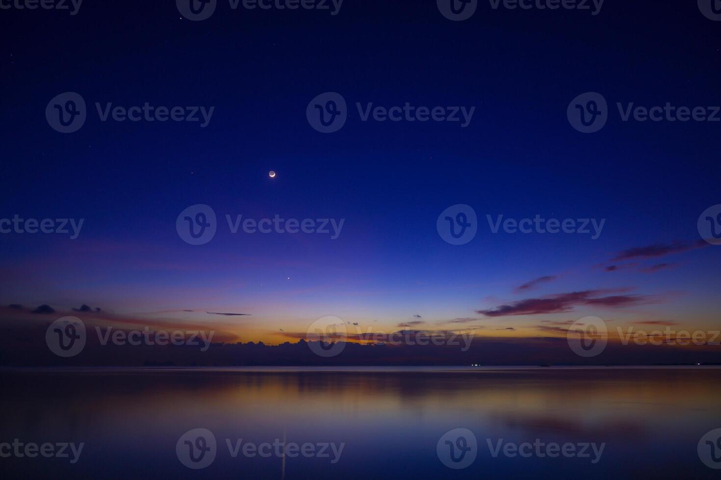 The moon and first star on sky at the lake in the twilight after sunset. photo