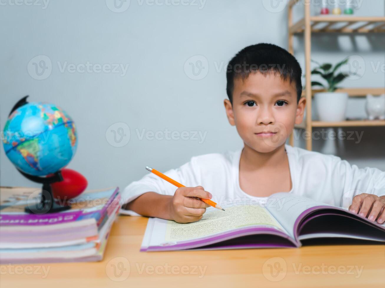 Student learning study reading book while sitting at home. Education, Childhood, People, Homework and school concept. Student boy with book writing to notebook at home. photo