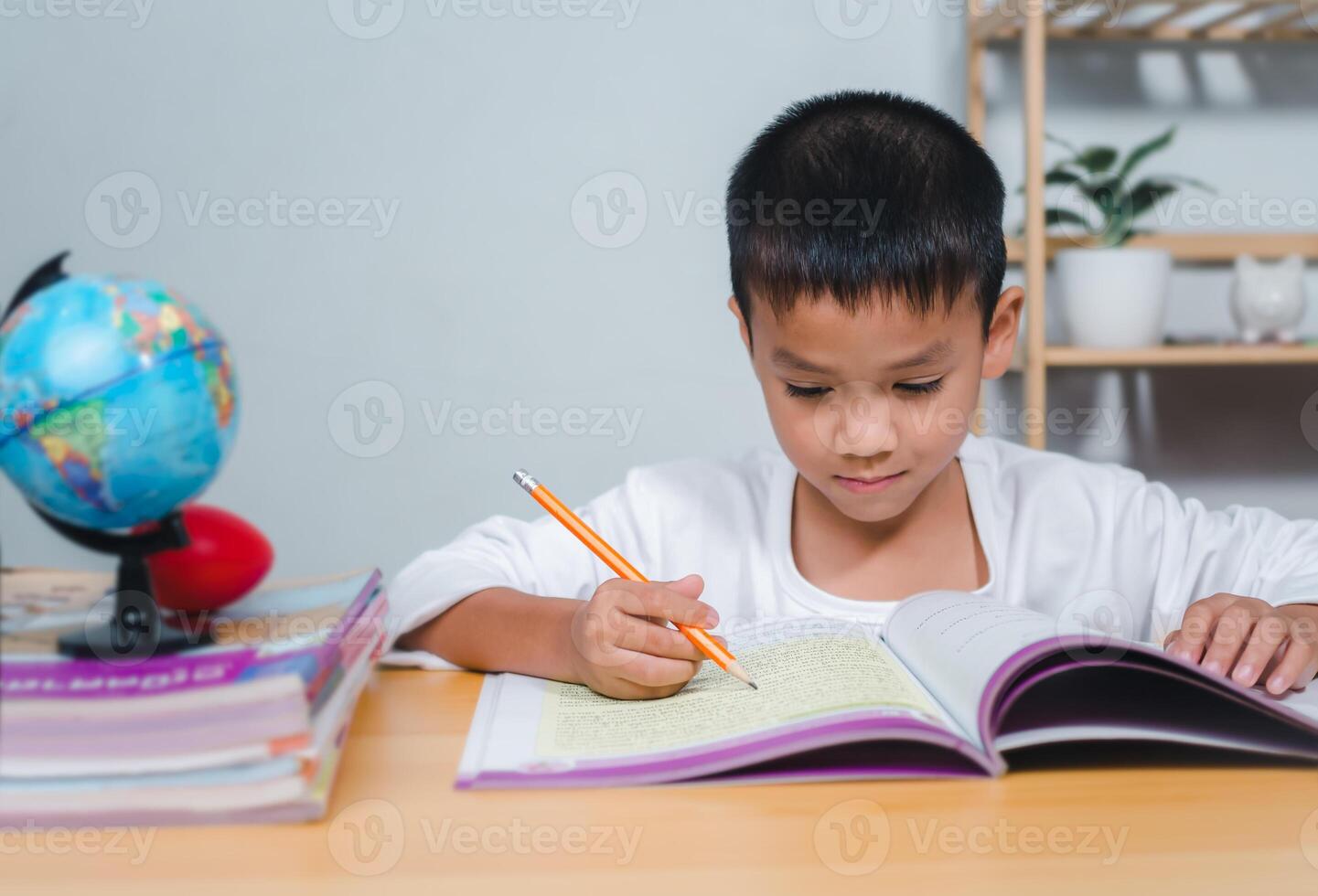 Student learning study reading book while sitting at home. Education, Childhood, People, Homework and school concept. Student boy with book writing to notebook at home. photo