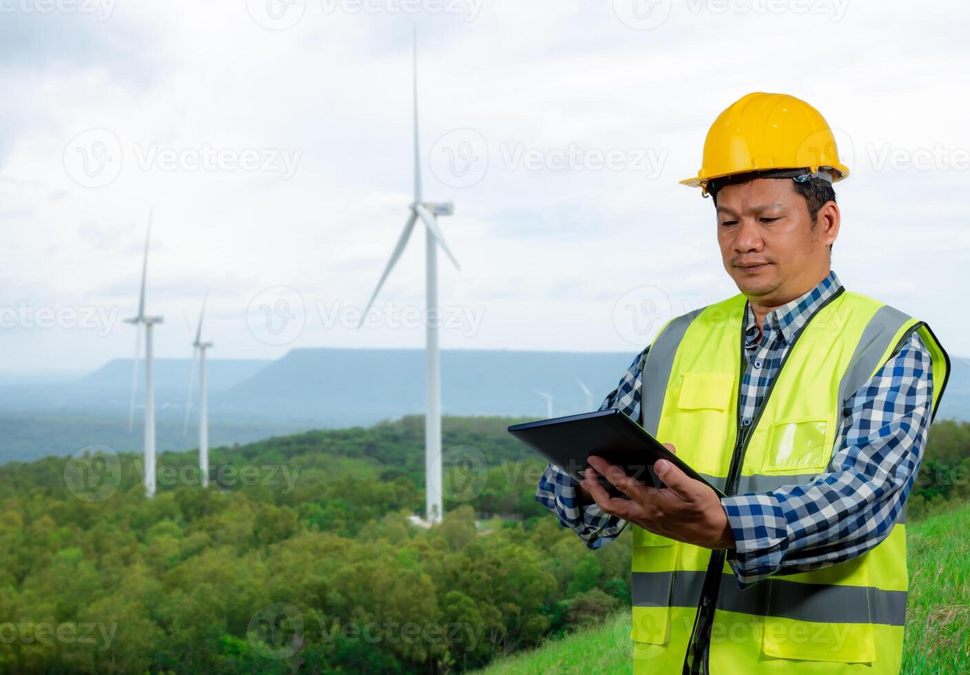 Engineer checking control electric power, Engineer man working with tablet at windmill farm Generating electricity clean energy, Wind turbine farm generator by alternative green energy. photo