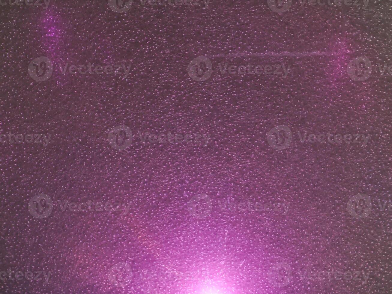 Pink light reflections on a plastic sheet in the dark for an abstract background. photo