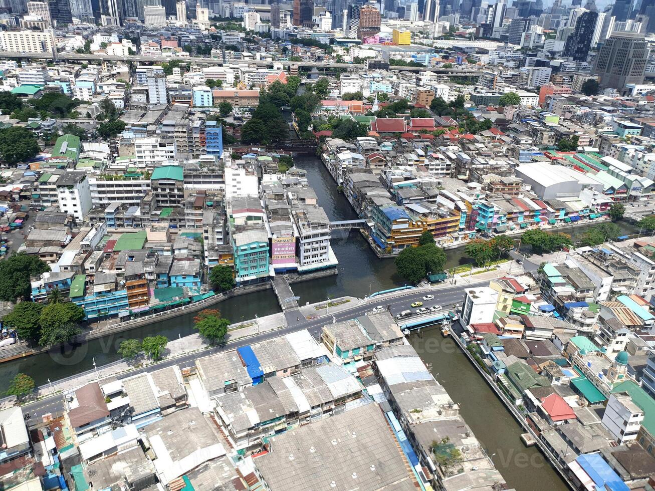 An aerial view from the top of a building showing the city below with a small river, streets, houses and skyscrapers in the background.Photography. photo