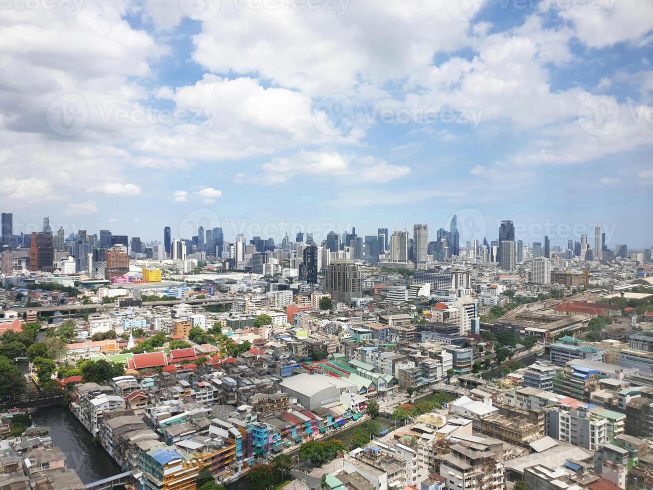 High angle view from the top of a building, seeing the city below, with a small river and road. Houses and skyscrapers serve as a backdrop..Photography. photo