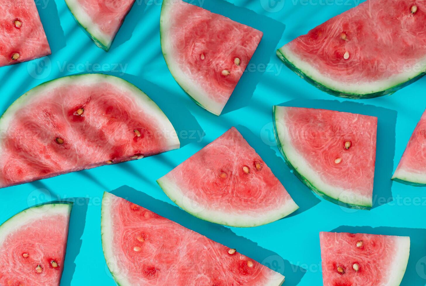 Trendy sunlight summer fruit pattern made with fresh watermelon slices and tropical palm leaf shadow on bright blue background. Sun and shadows. Creative minimal summer fruit concept. Flat lay. photo
