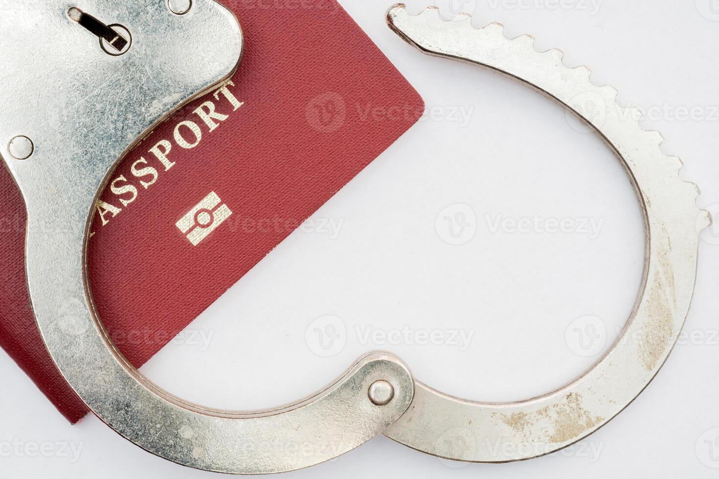 red passport on white background and handcuffs photo