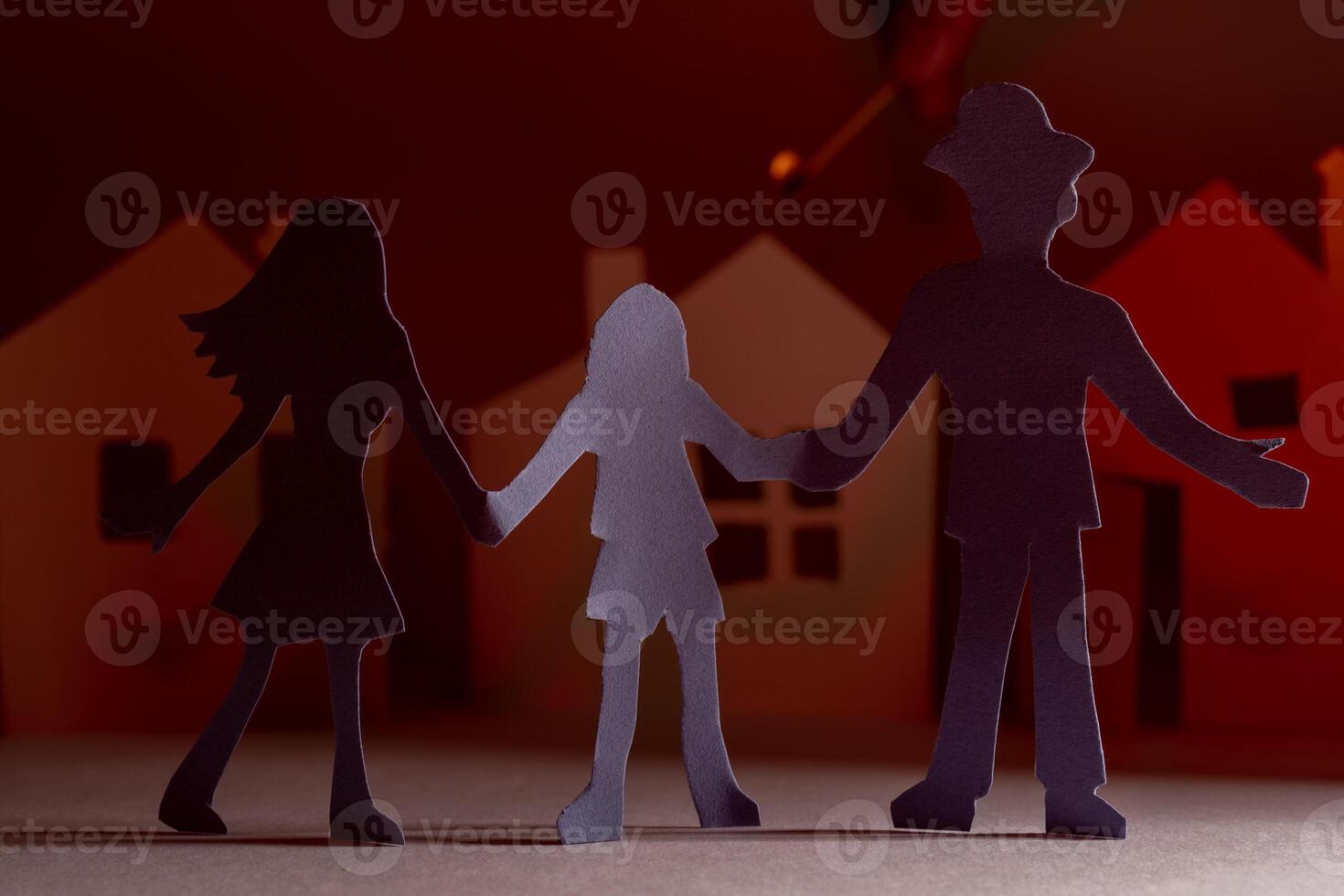 Cut from the paper family on the background of a burning paper house. photo