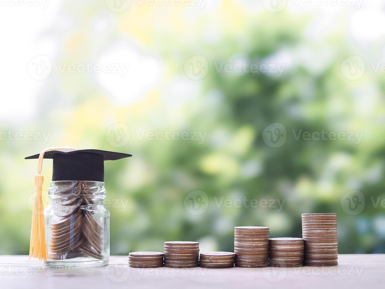 Glass bottle with graduation hat and stack of coins. The concept of saving money for education, student loan, scholarship, tuition fees in the future photo