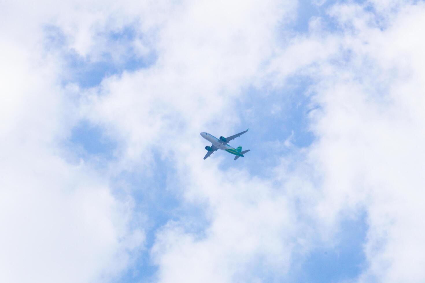 Looking up at an aeroplane in the middle of clouds from bottom photo